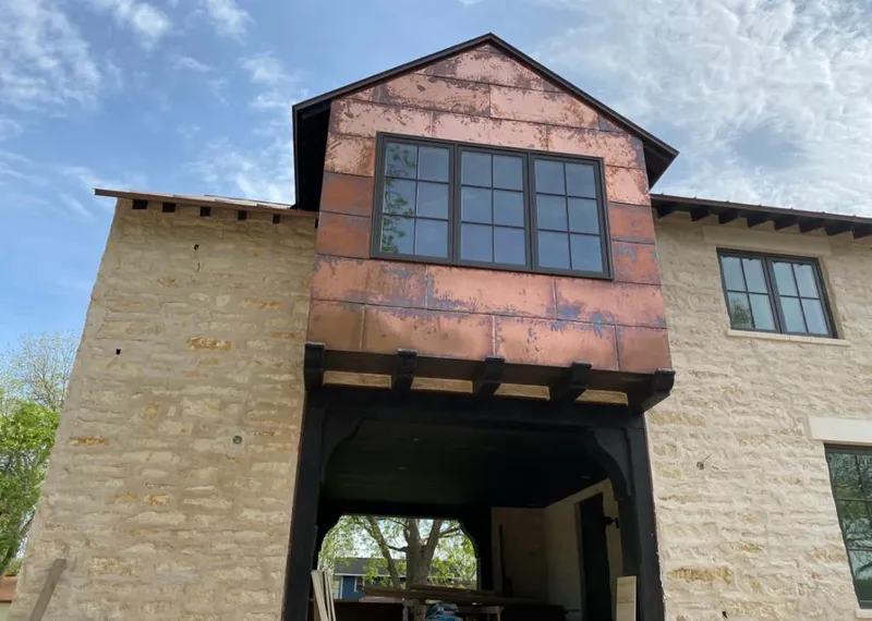 Copper metal panel facade on a stone building for Skylight Installation in Shorewood