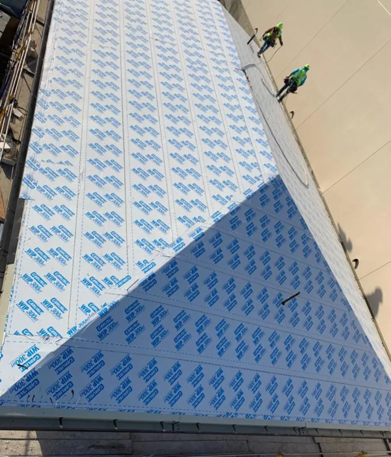 Professional roofers installing underlayment on a metal roof in Shorewood